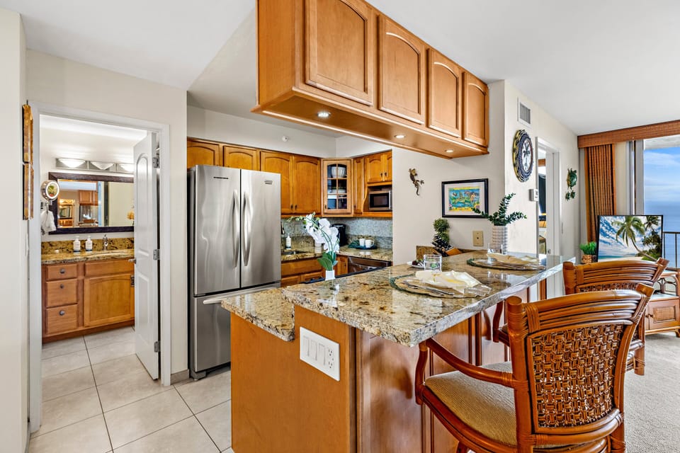 The open kitchen features generous counter space, modern appliances, and bar seating.