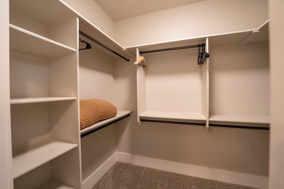 Spacious walk-in closet with built-in shelves and plenty of hanging space