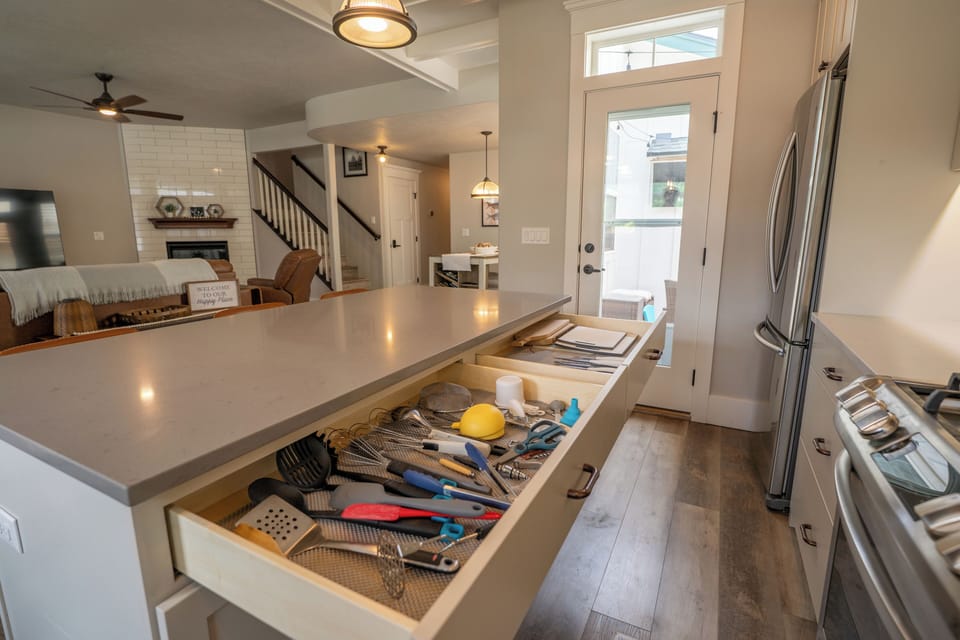 Bright open kitchen with spacious island, fireplace views, and outdoor access