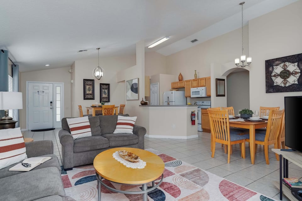 Spacious living area w/ round dining table & soft area rug.
