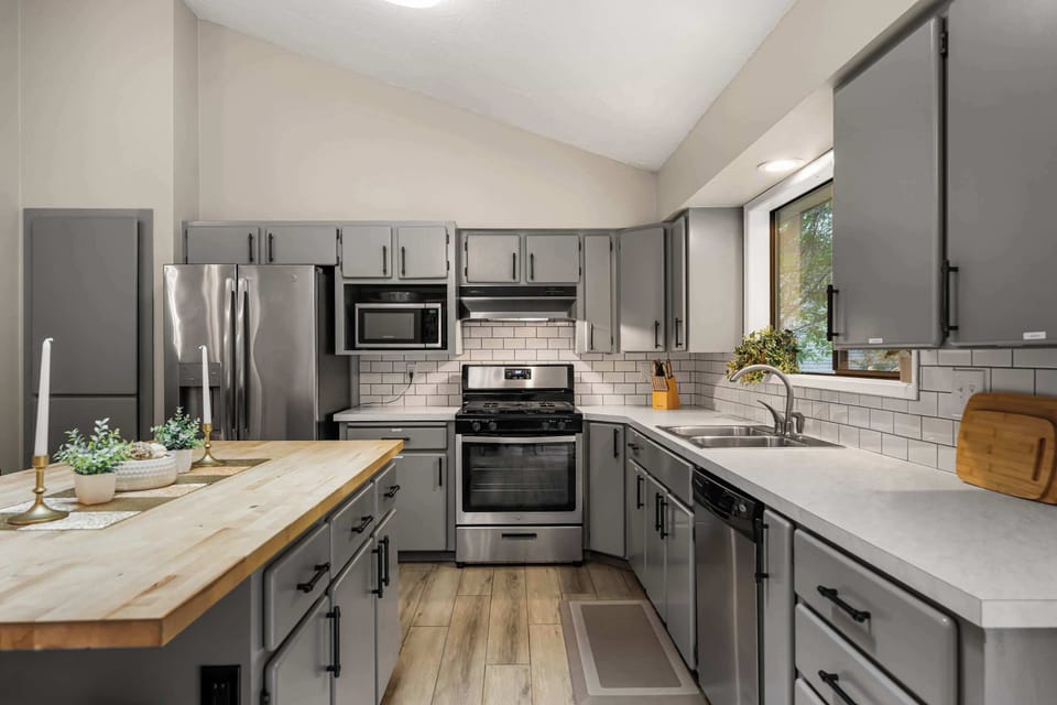 Full kitchen with butcher-block island, stainless gas range and fridge — plenty of room for the whole crew to cook