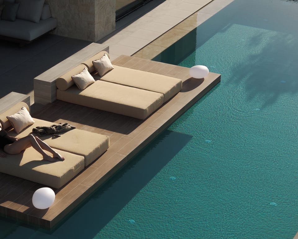 The outdoor in-pool sun beds invite guests to drift between water, shade, conver