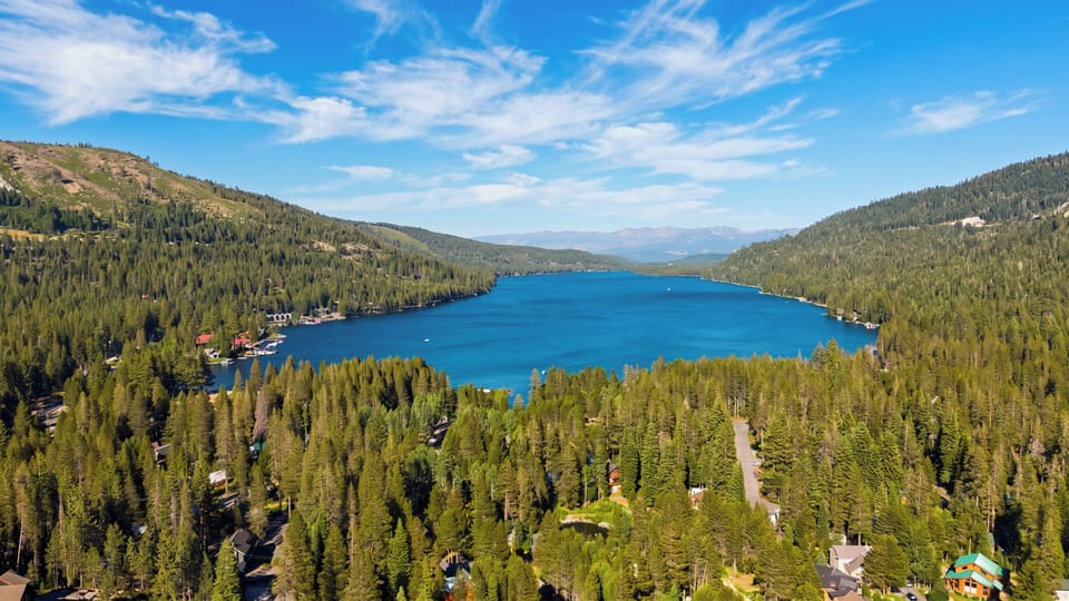 Enjoy breathtaking, panoramic views of the pristine blue lake and surrounding pine forest from this stunning elevated vantage point.