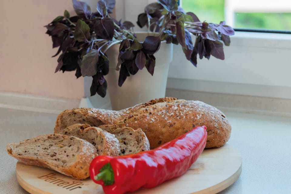 Fresh bread and vegetables prepared on a serving board. The arrangement adds a warm, homely touch.