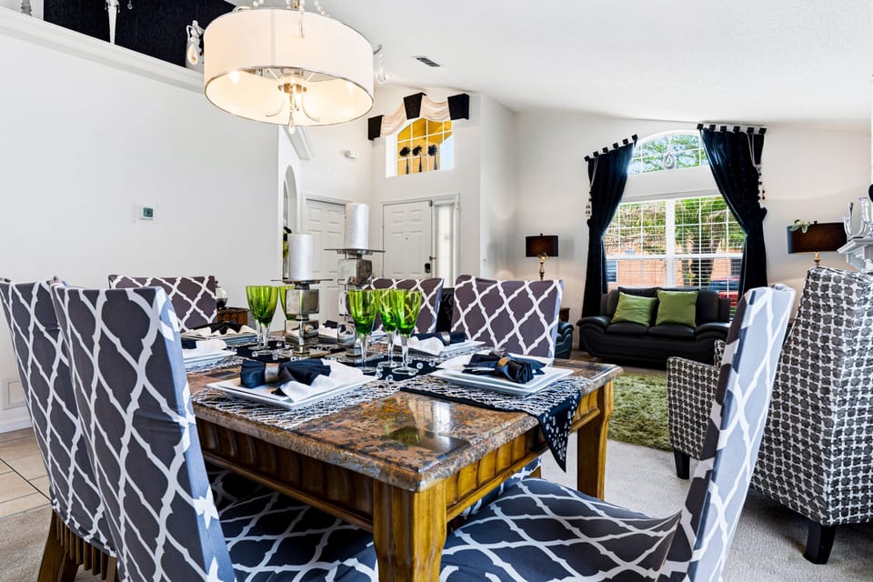 Gather around the elegant dining table with seating for six, perfect for family dinners, celebrations, or planning your next Orlando adventure together.
