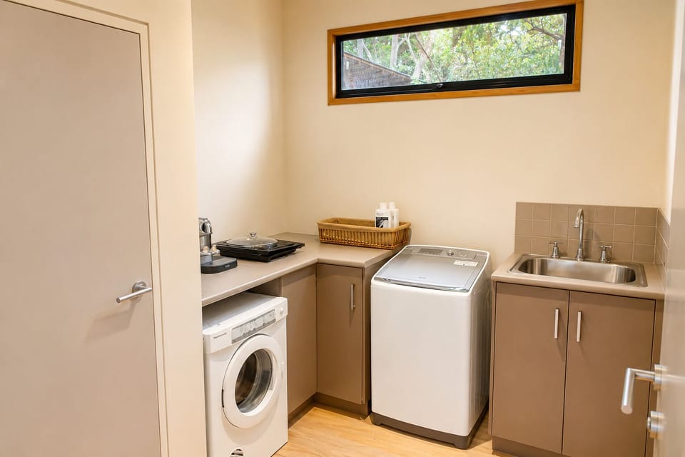 Bright, functional laundry room with washer, sink, and handy counter space