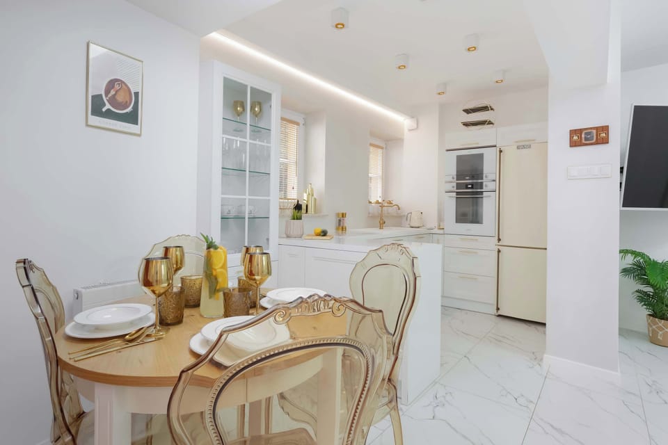 The dining area opens directly into the kitchen, creating a spacious environment for entertaining. Light colors make the room feel bright and inviting.