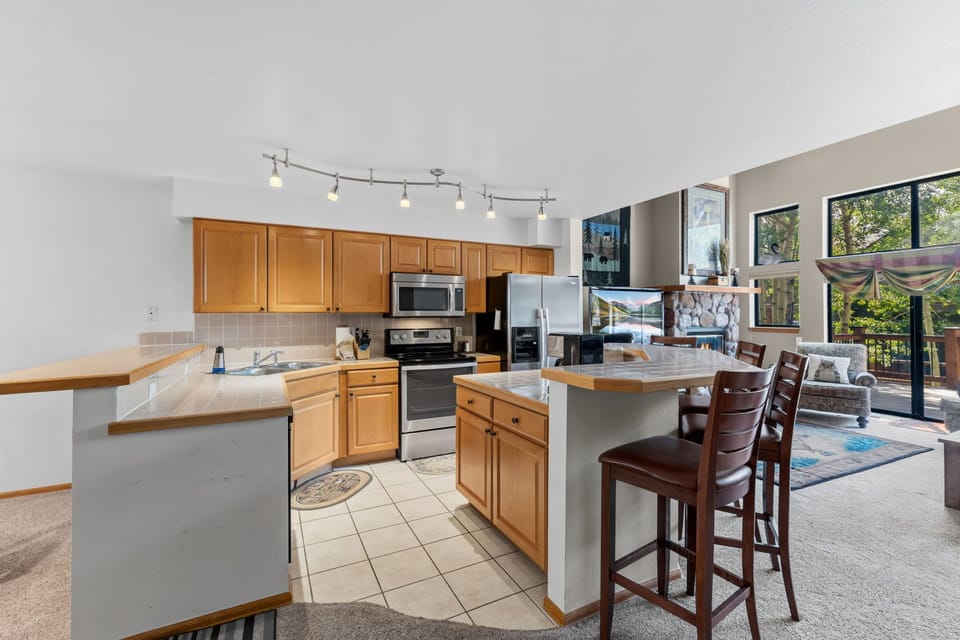 Your open-concept space blends the kitchen and living area seamlessly, where you'll whip up meals at warm wood counters while staying connected to your guests lounging by the windows.