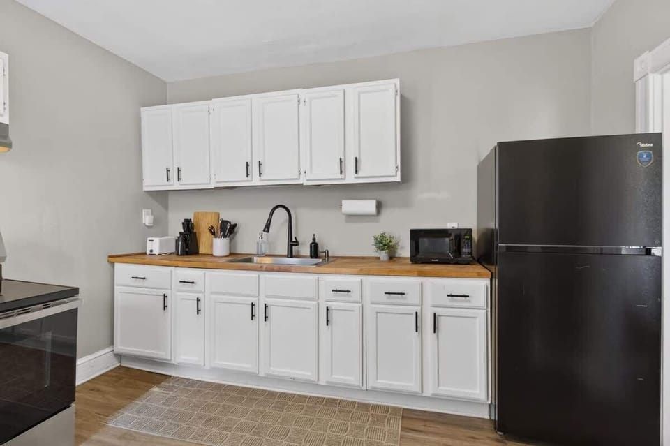Bright and functional kitchen with white cabinetry, modern appliances, and everything needed for easy meals during your stay.