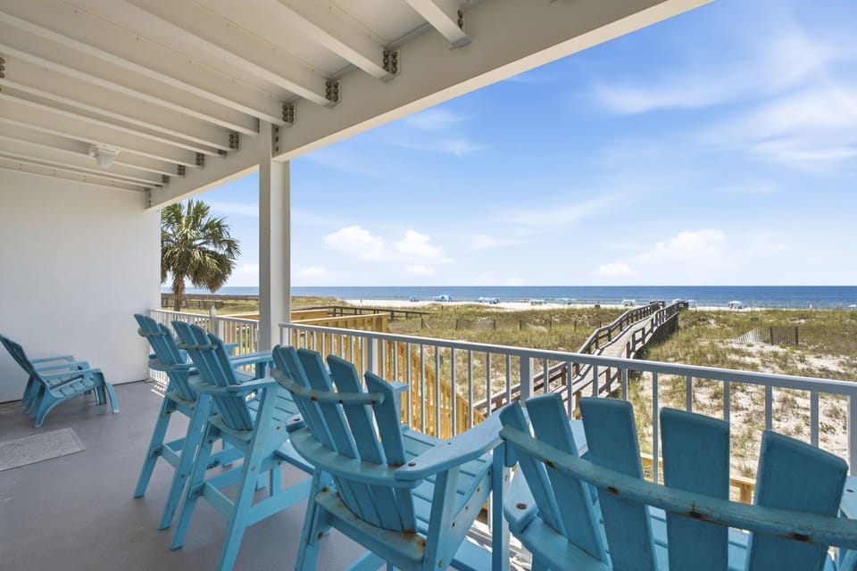 Picture yourself relaxing in this spacious beachfront retreat, where turquoise lounge chairs await and sweeping ocean views stretch endlessly before you. Your private beach boardwalk access makes sandy toes just steps away.