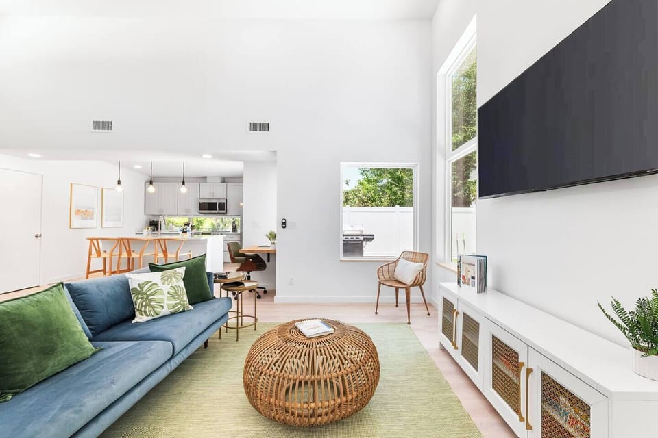 Kick back in style with this bright, open-concept living room—complete with a smart TV, cozy seating, and views of the private backyard grill area. ✨ 