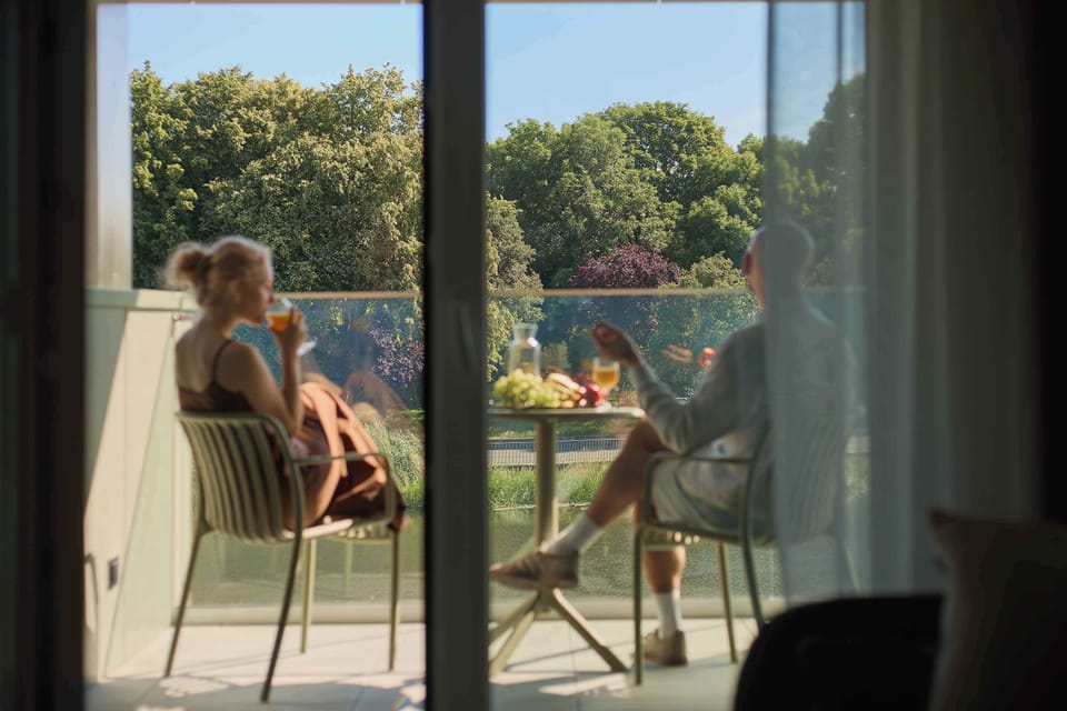 Wyjątkowym atutem apartamentu jest balkon z widokiem na rzekę, wyposażony w meble wypoczynkowe. To idealne miejsce na poranną kawę, odpoczynek w ciągu dnia lub spokojny wieczór w otoczeniu zieleni.