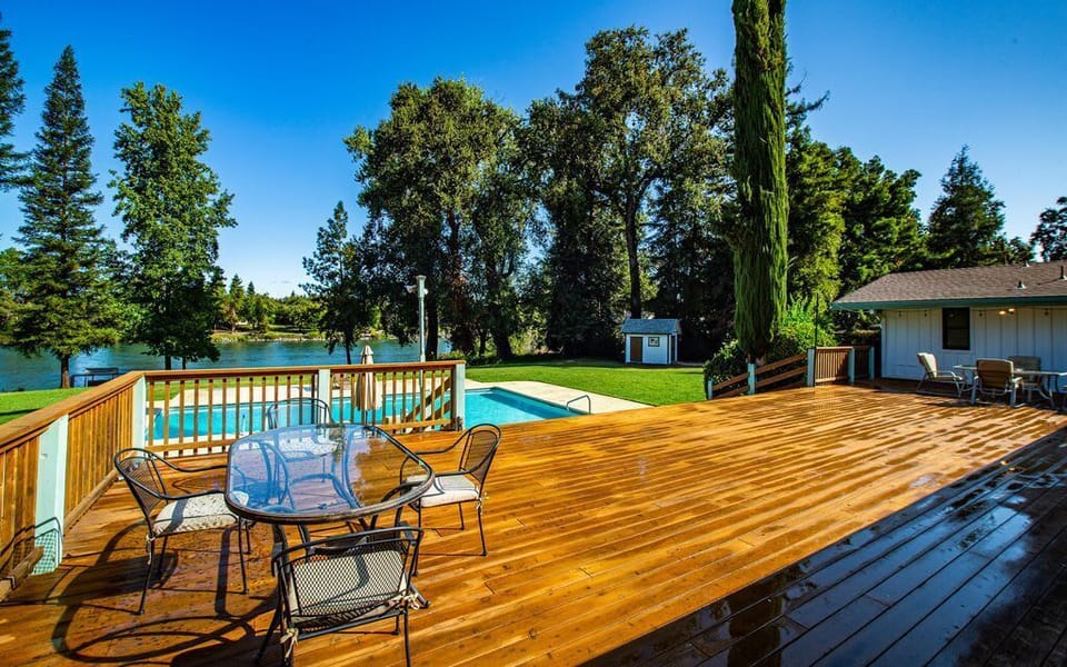 The large redwood deck overlooks the pool, hot tub and the river