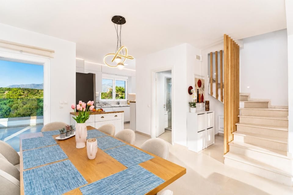 Bright dining area with modern lighting, stylish decor, and beautiful countryside views.