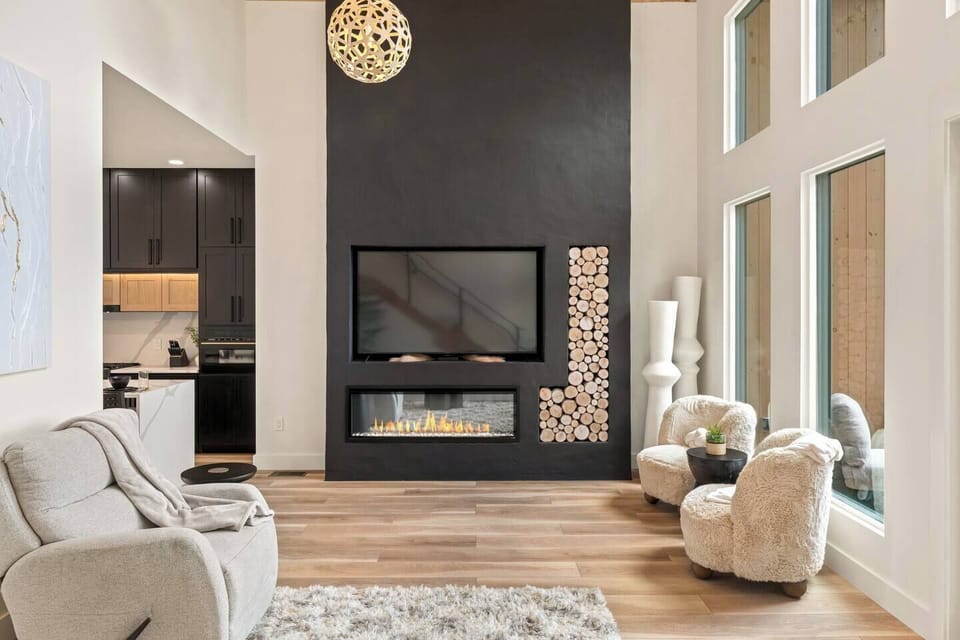 Relax in the grand living room featuring soaring cathedral ceilings, a large screen TV, a cozy fireplace, and luxurious seating.  The perfect setting to relax after a busy day in the Smokies.