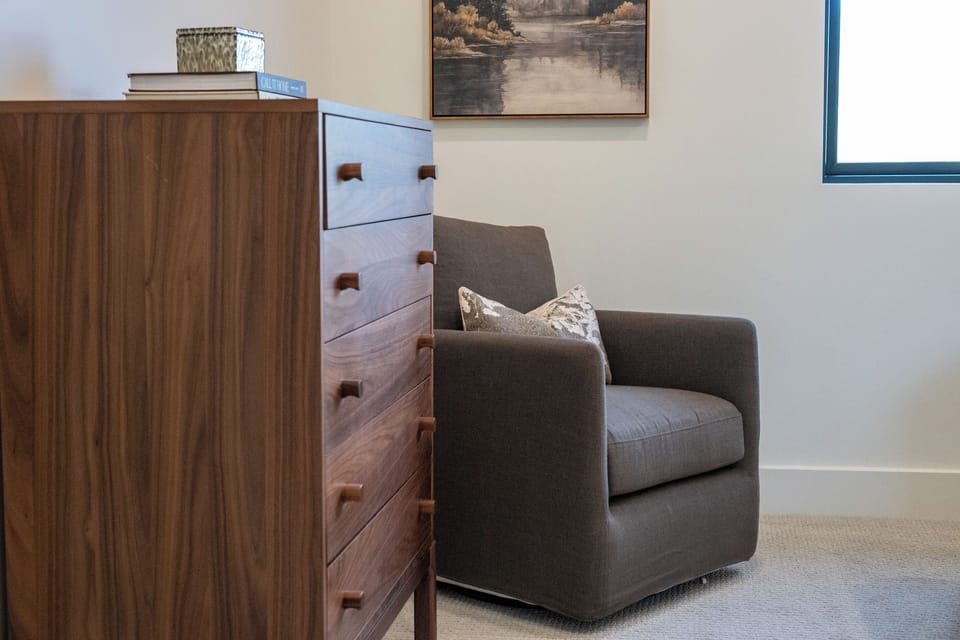 Cozy reading chair and dresser in the main-level bedroom.