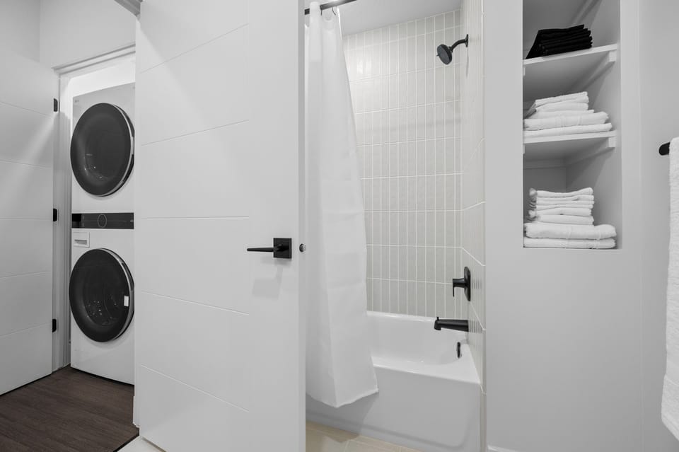 Fresh towels and modern finishes throughout the bathroom.