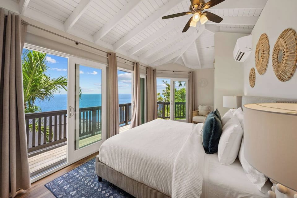 Cozy king bedroom featuring private balcony access and beautiful ocean views.
