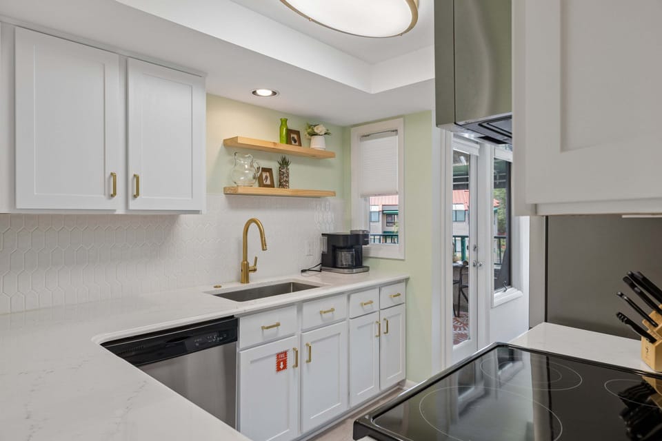 Galley-style kitchen has been thoughtfully refreshed with crisp white cabinetry