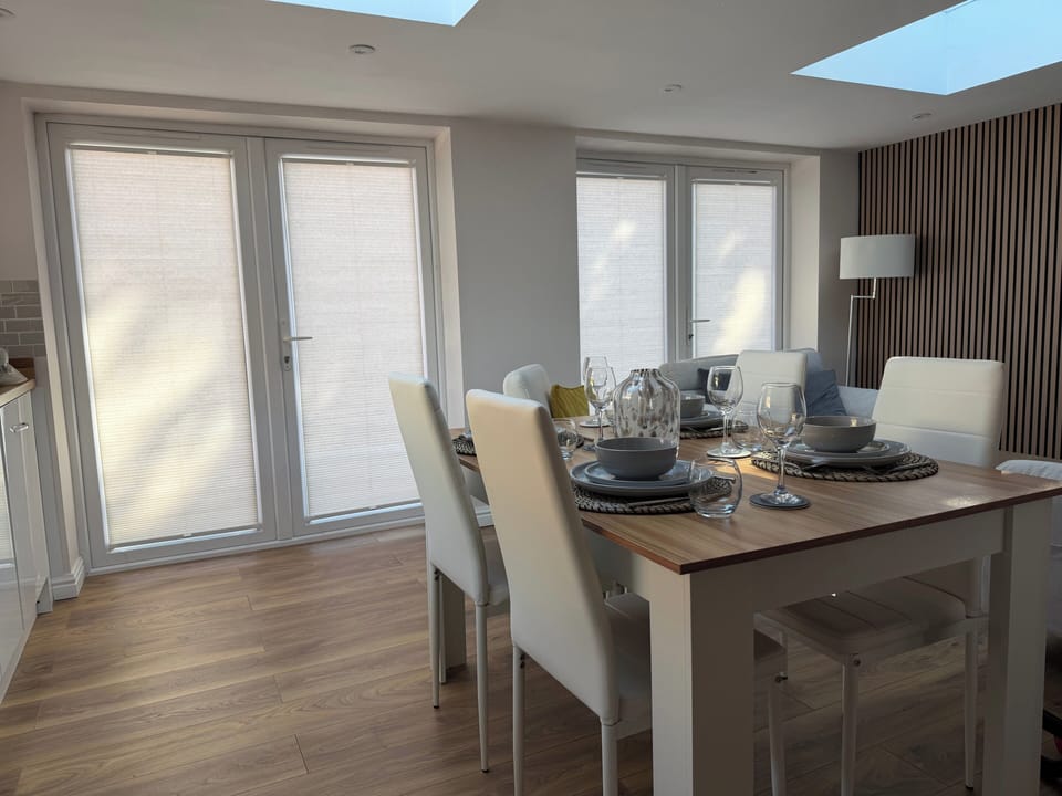 Room with dining table and chairs and blinds to the French doors for privacy 