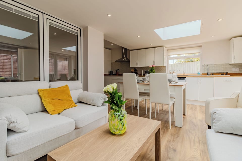 Living area featuring:
- settees and chairs
- coffee table
- TV
- LED lighting
- dining table and chairs
- laminate flooring