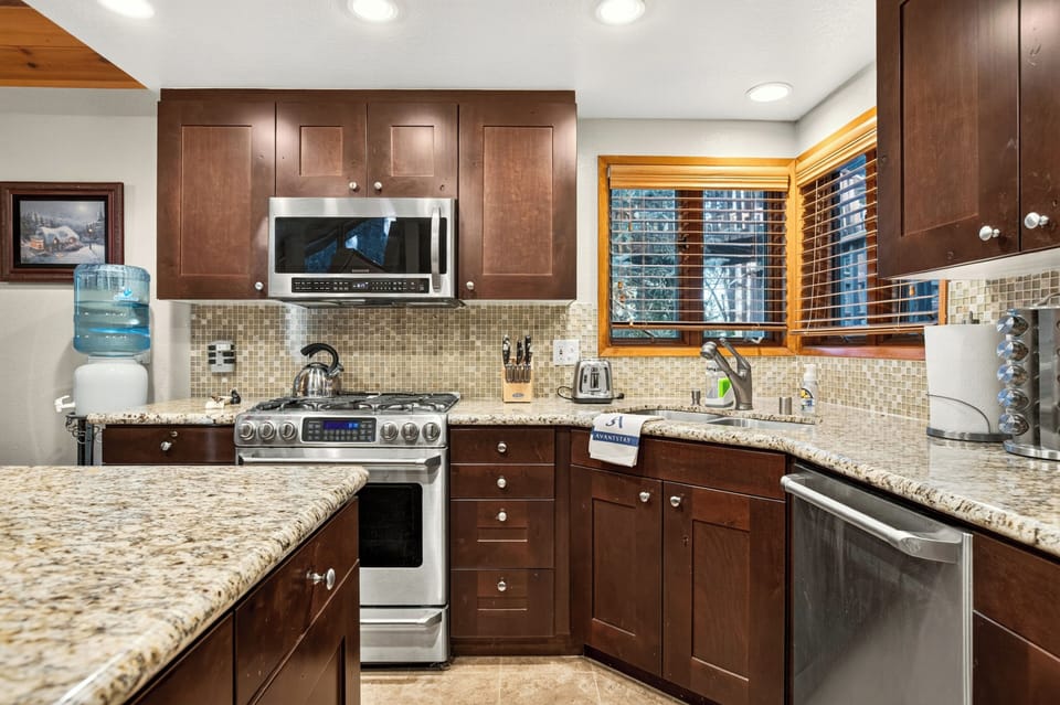 Kitchen and dining area with island seating, stainless steel appliances, and easy access to the upper level.