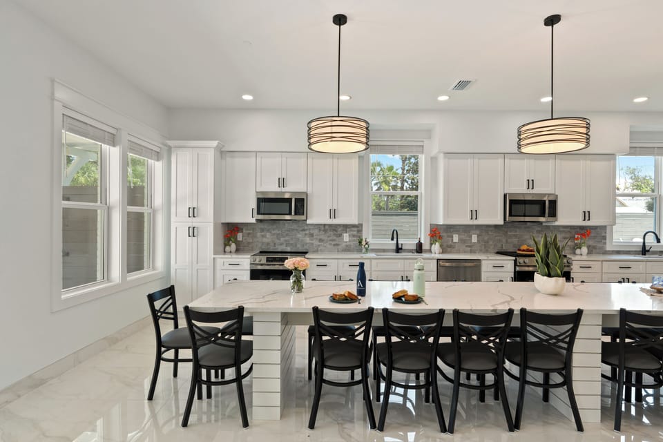 Expansive chef’s kitchen with double appliances, oversized island seating, and sleek modern finishes.