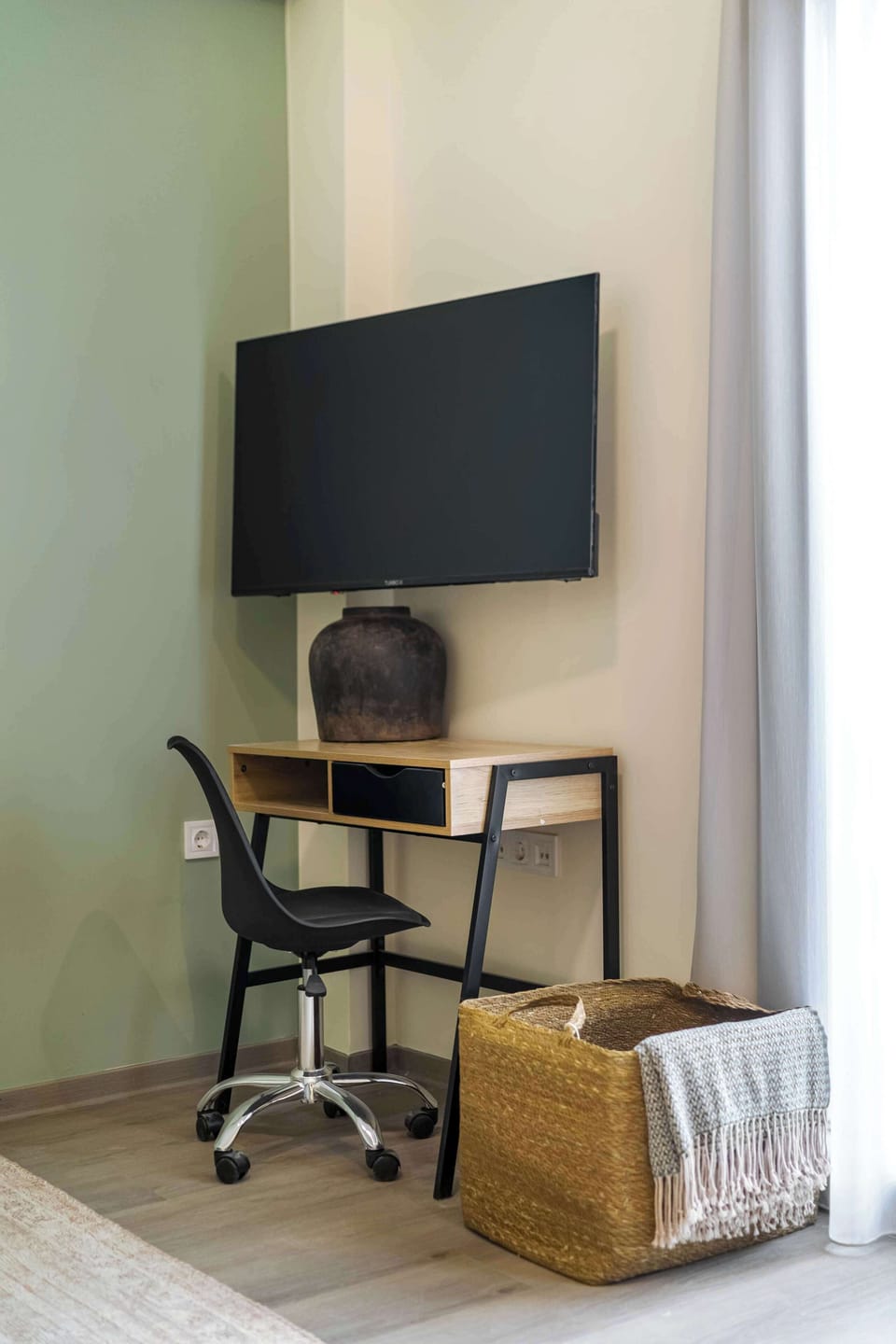 Compact desk beneath television provides convenient spot for work, planning itineraries, or quick laptop sessions.