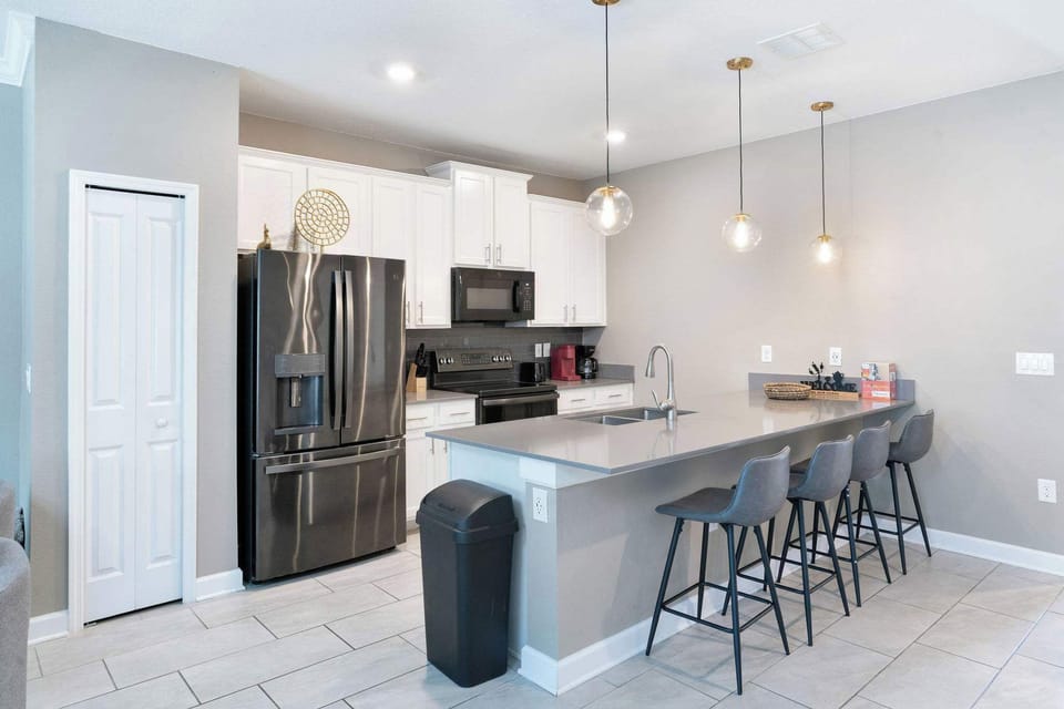 Prepare meals, snacks, and drinks together in a modern kitchen with a large island and plenty of seating.