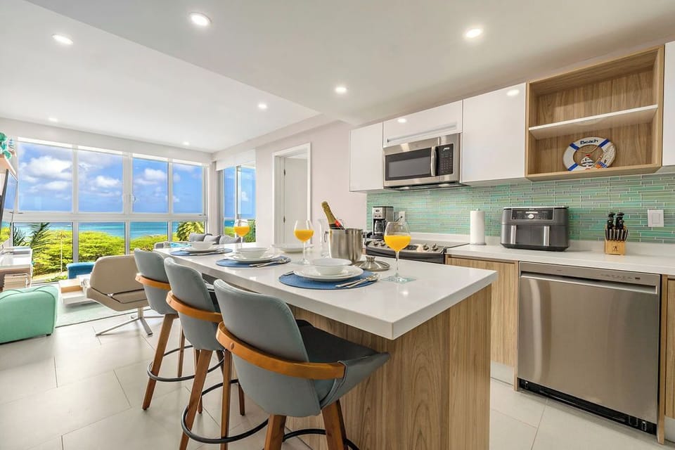 Your bright, modern kitchen with sleek stainless appliances, island seating, and ocean views makes every meal feel like a celebration of paradise.