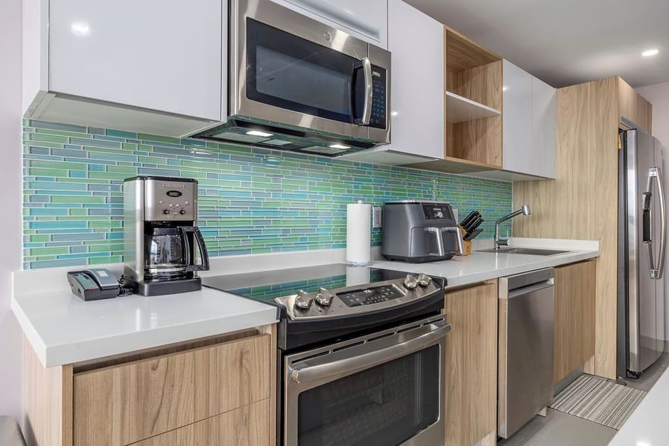 Your fully-equipped modern kitchen features sleek stainless steel appliances, vibrant tile backsplash, and everything you need to prepare meals during your stay.