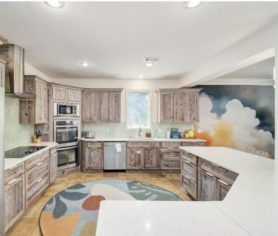 The open kitchen keeps the conversation flowing from the island to the dining table, making every meal part of the vacation.