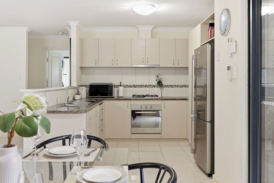 Enjoy sleek stainless steel appliances, plenty of prep space, and a beautiful glass dining table ready for your next home-cooked meal. (A