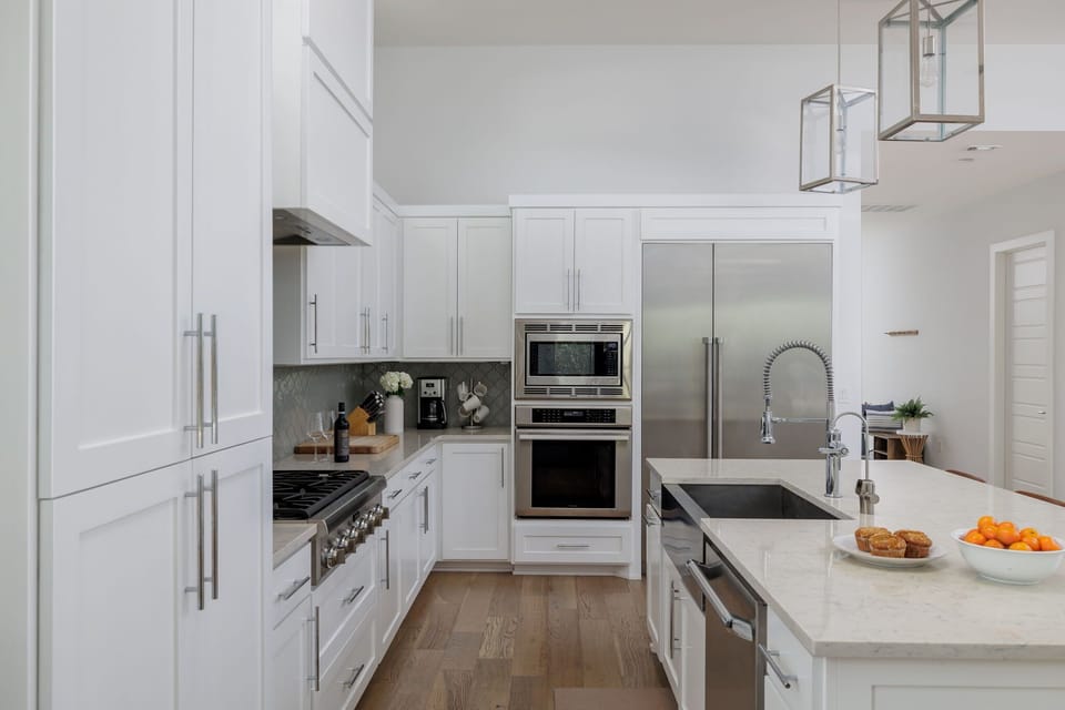 This fully equipped chef's kitchen offers premium stainless steel appliances, double ovens, generous counter space, and everything needed for home-cooked meals.