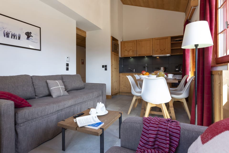 The same warm wood tones and red accents run throughout the apartment, tying the Alpine aesthetic together.