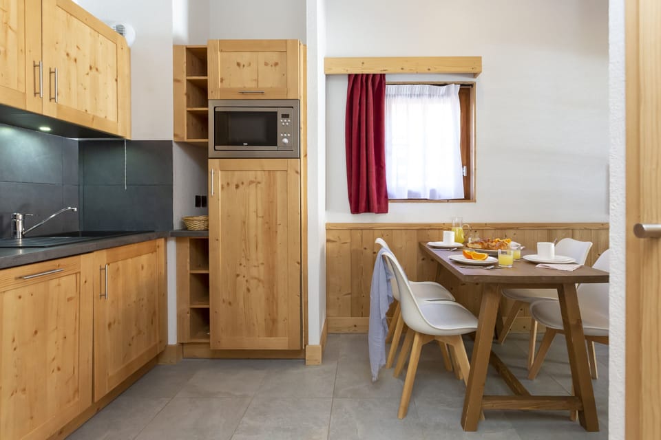 The kitchenette is fully equipped with a ceramic hob, microwave, and dishwasher — everything you need to fuel up before heading to the slopes.