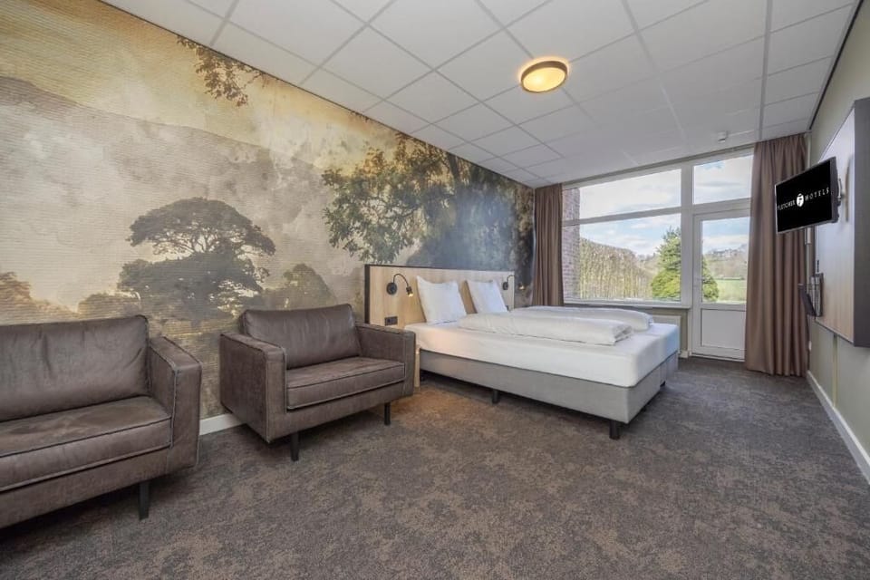 Lounge comfortably in the room’s seating area beneath scenic wall art.