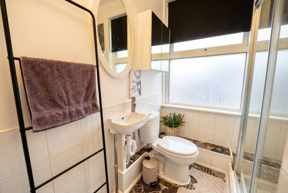 Bright shower room with heated towel rail and playful wall art.