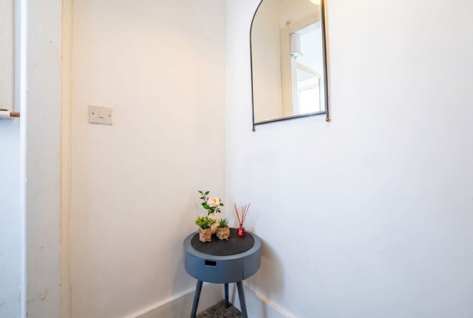 Quiet corner nook with mirror and fresh florals for a welcoming touch.