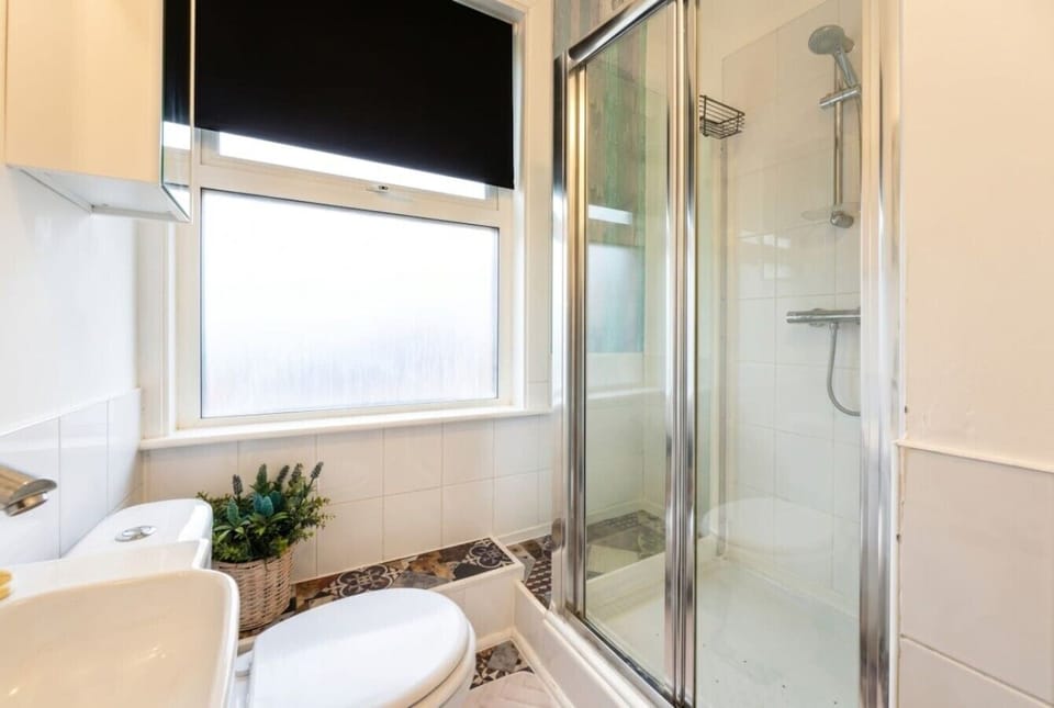 Fresh shower room with glass enclosure and a bright frosted window.