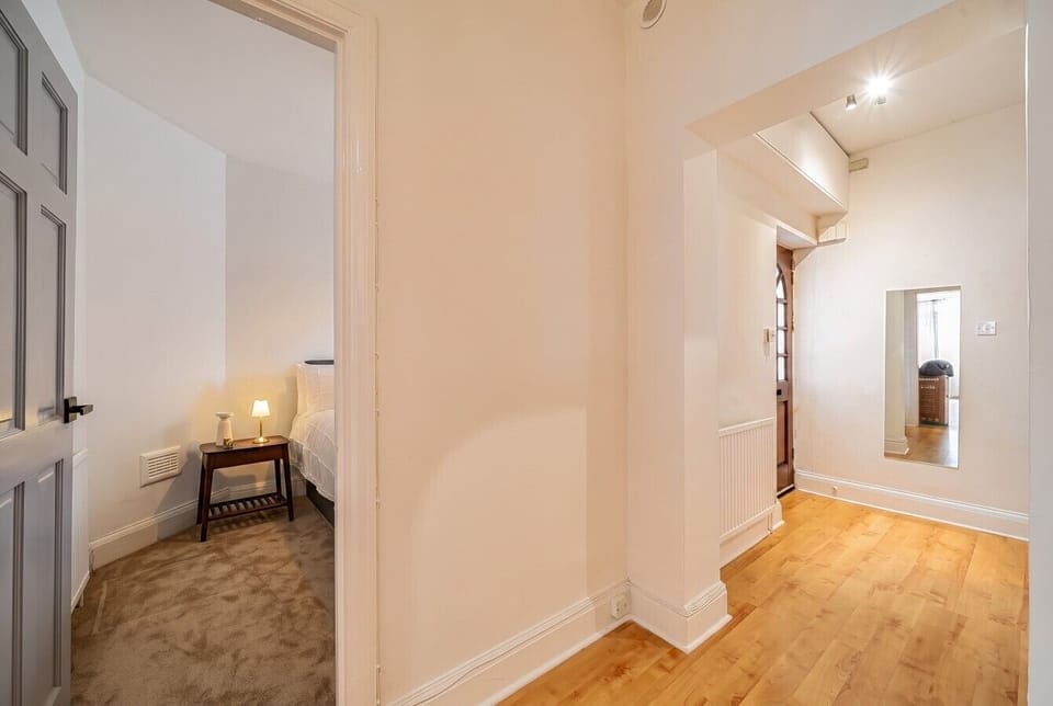 Bright hallway with warm wood floors linking bedrooms and living spaces