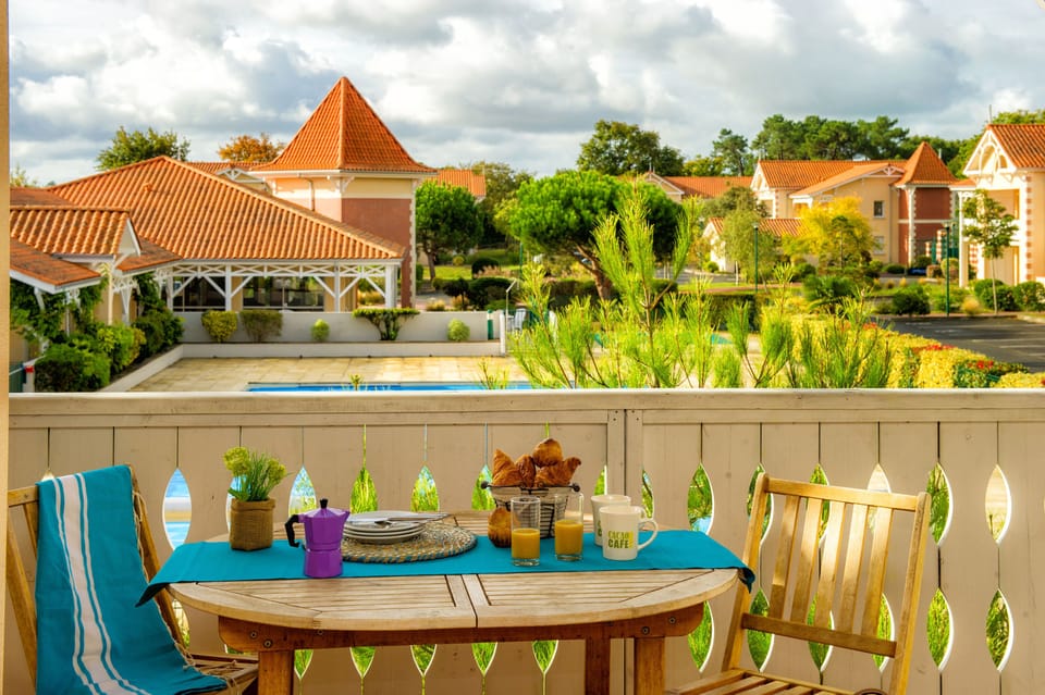 Breakfast on the furnished terrace with park and pool views — a two-minute walk from the beach path.