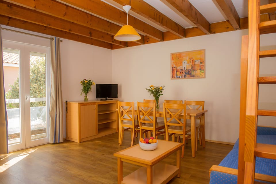 The spacious open-plan living and dining area, with a mezzanine level and direct access to the private terrace.