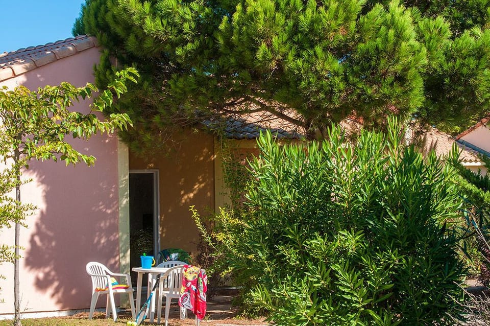 A shaded terrace surrounded by Mediterranean greenery, the perfect spot to relax outside your villa.