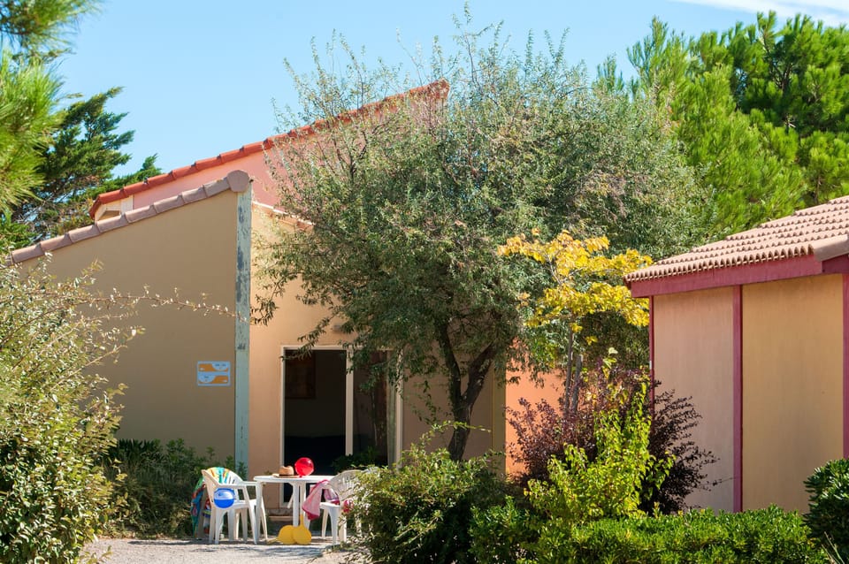 A private terrace shaded by an olive tree, just outside your villa door.