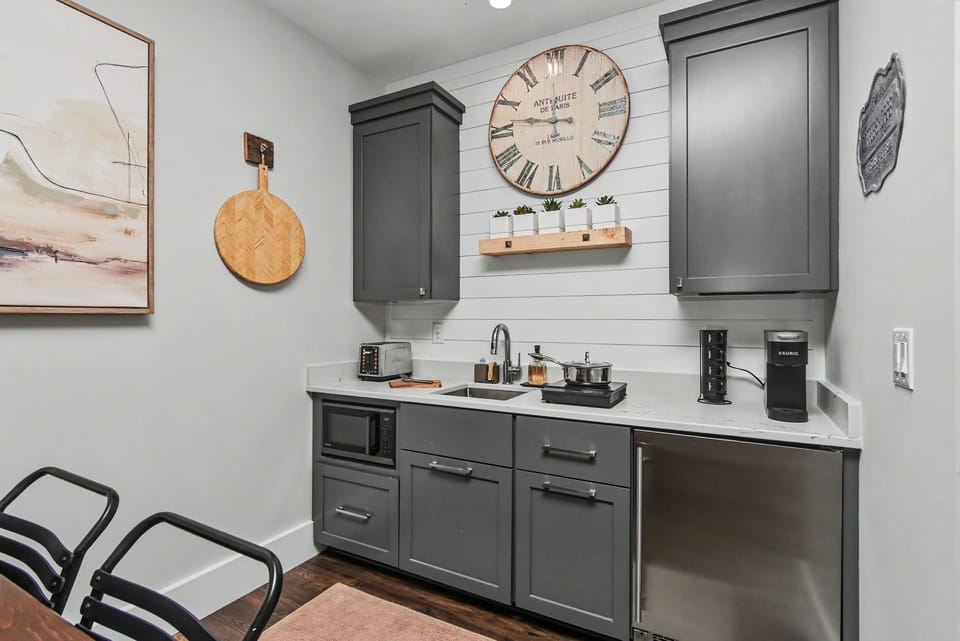 Chic kitchenette with modern finishes, mini fridge, and cozy design touches
