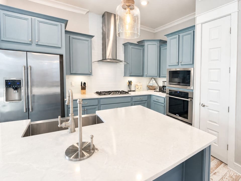 Bright designer kitchen with large island and premium stainless appliances