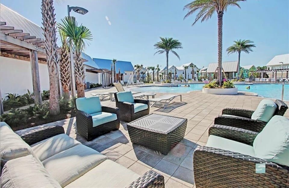 Resort-style pool deck with palm views and chic outdoor lounge seating