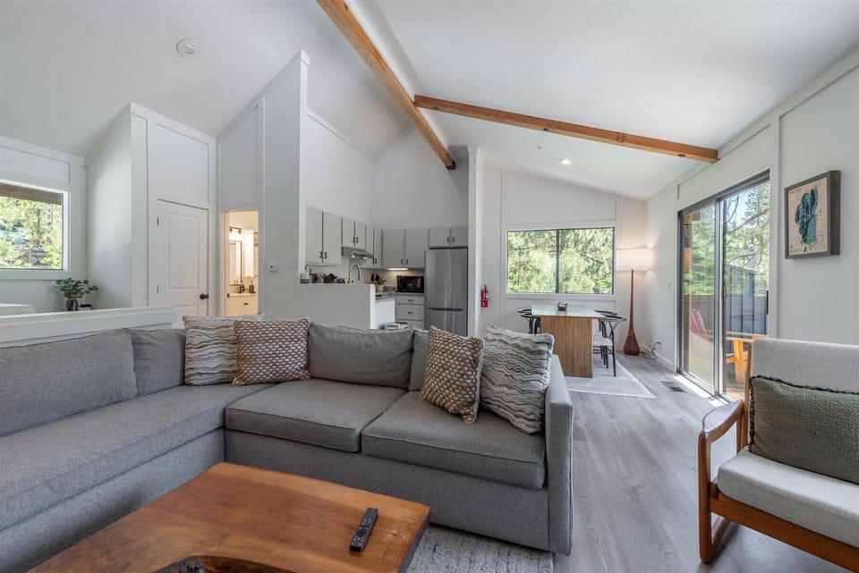 Relax in your bright, open living space where vaulted ceilings with warm wood beams create an airy retreat. Sink into the plush sectional, enjoy your fully equipped kitchen, and step out to your private balcony.