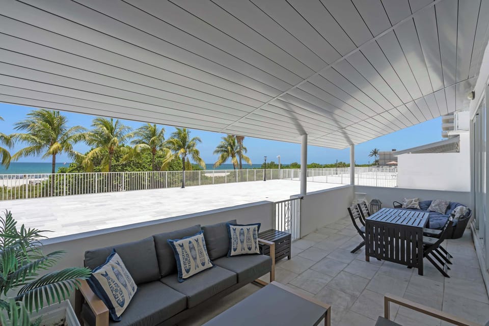 Expansive covered terrace with lounge seating, an outdoor dining set, and sweeping ocean views—the ultimate spot for al fresco meals, sunset drinks, and coastal relaxation.